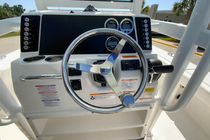 Slide: The Image of 2024 Robalo 246 Cayman boat dashboard with steering wheel and control panel. - 16