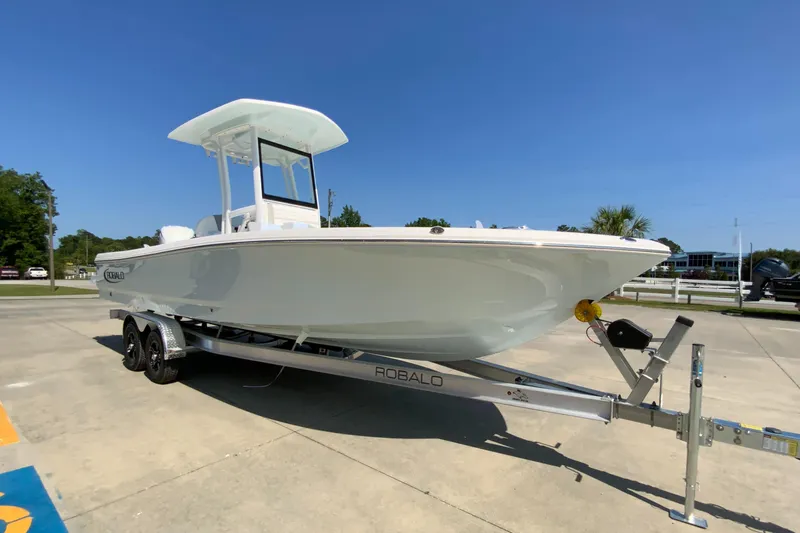 Slide: The Image of 2024 Robalo 246 Cayman boat on trailer in sunny outdoor setting. - 2