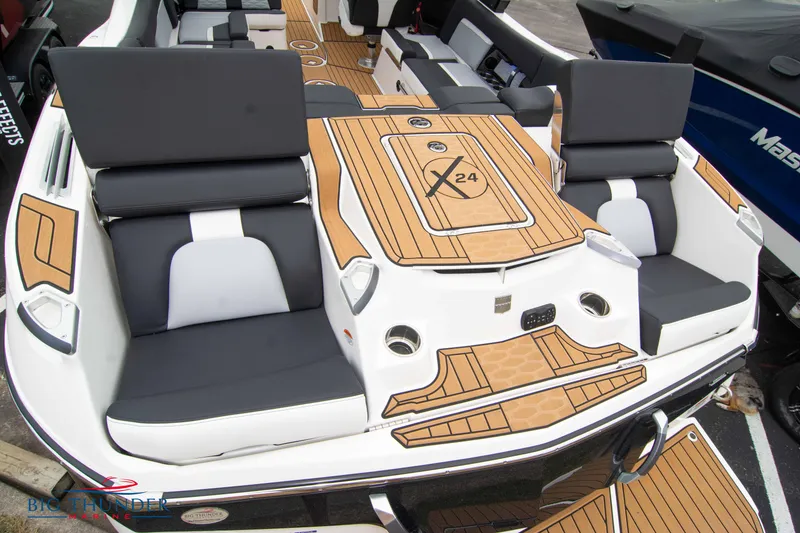 Slide: The Image of 2023 MasterCraft X24 boat interior with luxurious seating and teak flooring. - 12