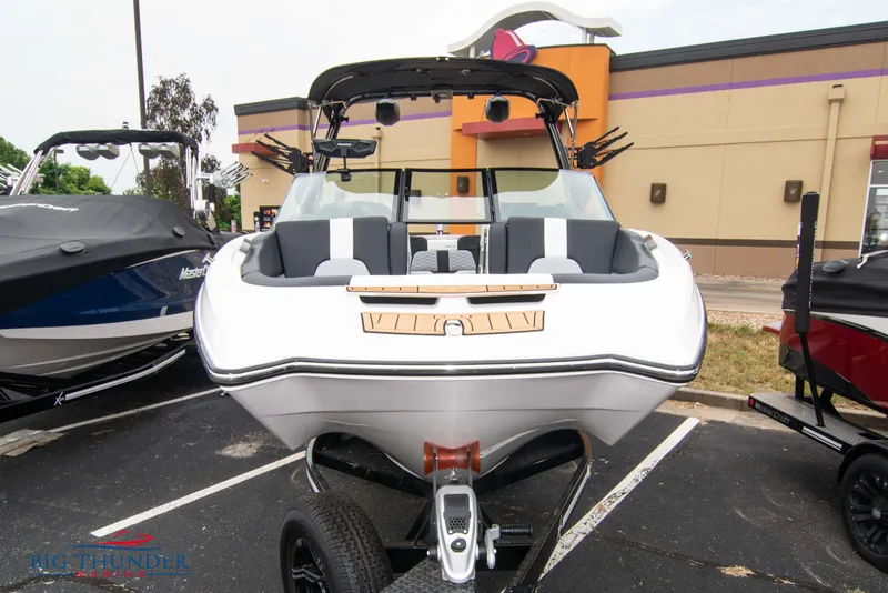 Slide: The Image of 2023 MasterCraft X24 boat on trailer in parking lot. - 2