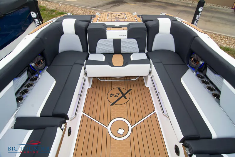 Slide: The Image of 2023 MasterCraft X24 boat interior with luxurious seating and teak flooring. - 22