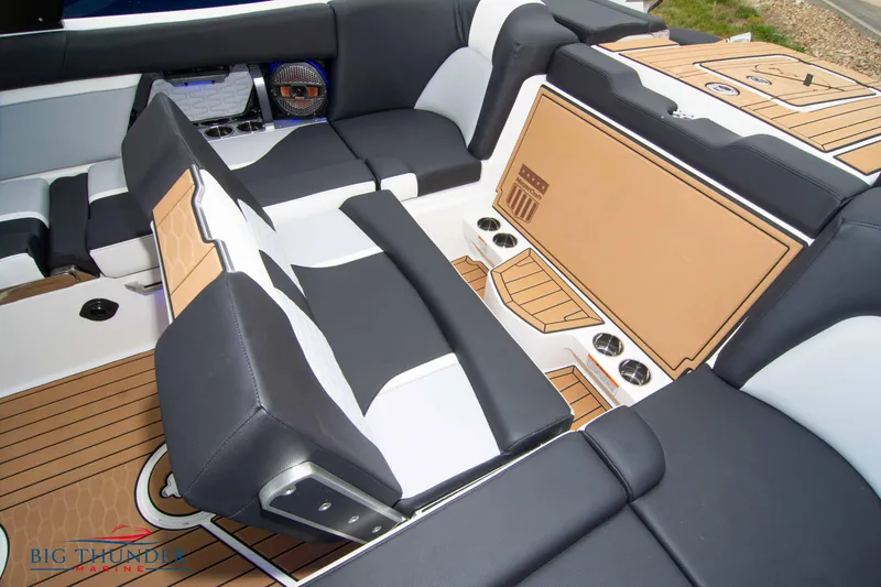 Slide: The Image of 2023 MasterCraft X24 boat interior with black and white seating and teak flooring. - 24
