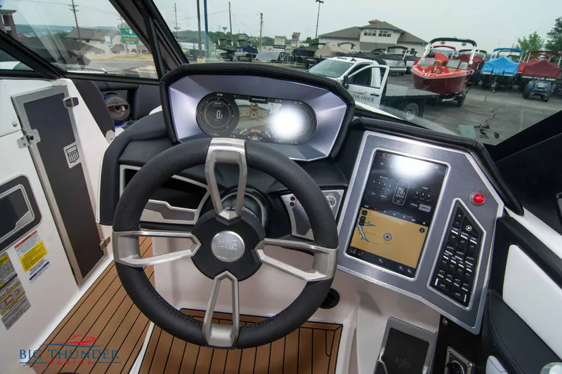 Slide: The Image of 2023 MasterCraft X24 boat dashboard with steering wheel and touchscreen controls. - 38