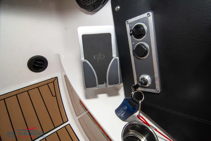 Slide: The Image of 2023 MasterCraft X24 boat control panel with key ignition and phone holder. - 41