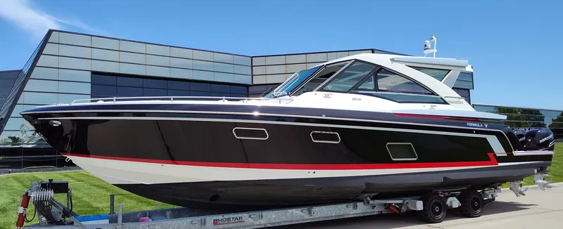 Slide: The Image of 2017 Formula 430 Super Sport Crossover boat on trailer, modern building background. - 4