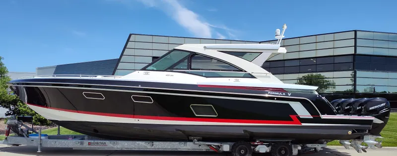 Slide: The Image of 2017 Formula 430 Super Sport Crossover boat on a trailer, modern building background. - 5