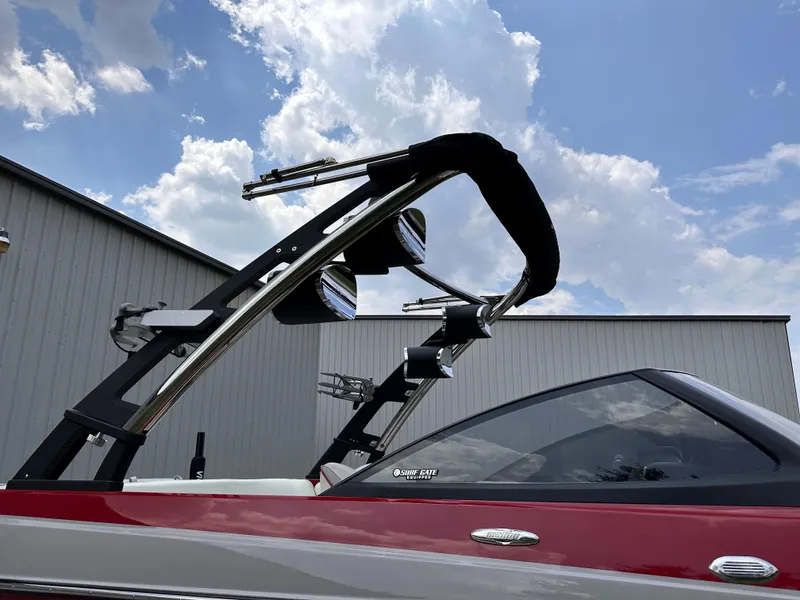 Slide: The Image of 2014 Malibu VTX Wakesetter boat with wakeboard tower against blue sky. - 6