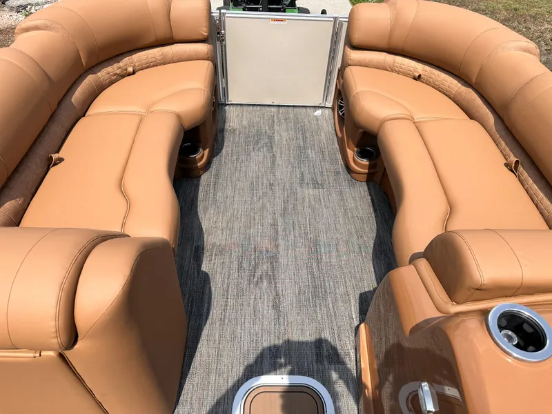 Slide: The Image of 2023 Avalon Catalina Quad Lounger 25 interior with tan leather seating and cup holders. - 14