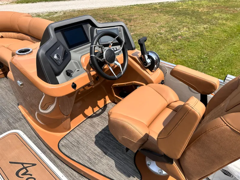 Slide: The Image of 2023 Avalon Catalina Quad Lounger 25 boat interior with steering wheel and captain's chair. - 7