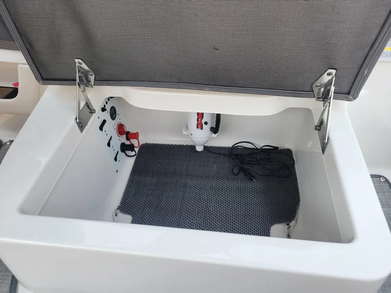 Slide: The Image of 2018 Chaparral 257 SSX storage compartment with open lid and visible wiring. - 15