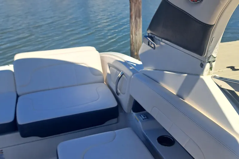 Slide: The Image of 2018 Chaparral 257 SSX boat interior with white seating and cup holder by the water. - 31