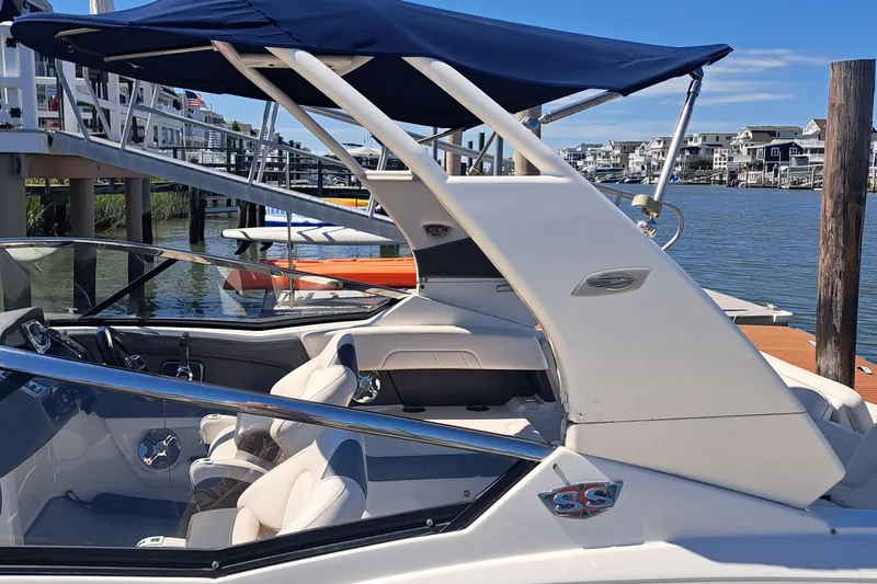 Slide: The Image of 2018 Chaparral 257 SSX boat docked, featuring sleek design and blue canopy. - 39