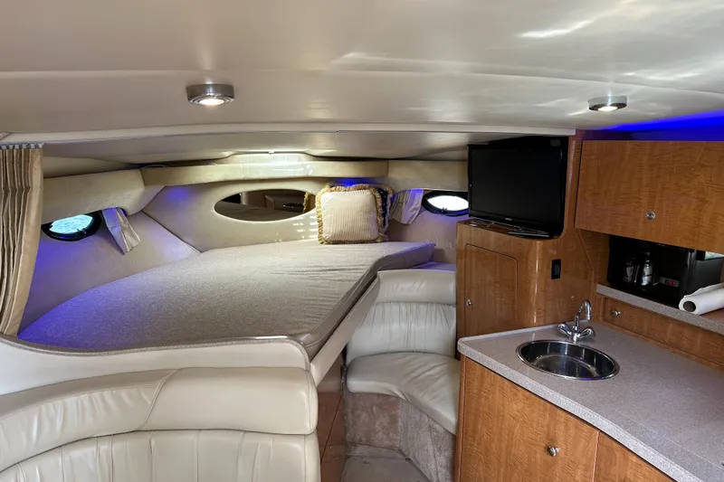 Slide: The Image of Interior of 2003 Regal 3260 Commodore yacht with bed, kitchenette, and TV. - 14