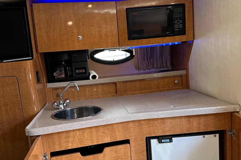 Slide: The Image of 2003 Regal 3260 Commodore yacht kitchen with sink, microwave, and mini fridge. - 15