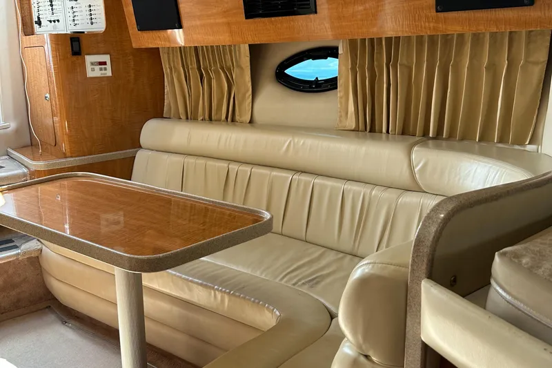 Slide: The Image of Interior of 2003 Regal 3260 Commodore yacht with leather seating and wooden table. - 19