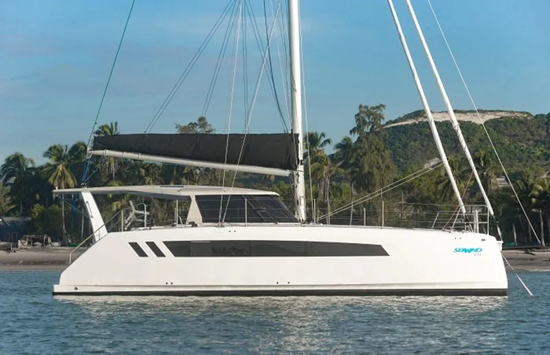 Slide: The Image of 2025 Seawind 1170 catamaran sailing on calm waters with tropical background. - 2