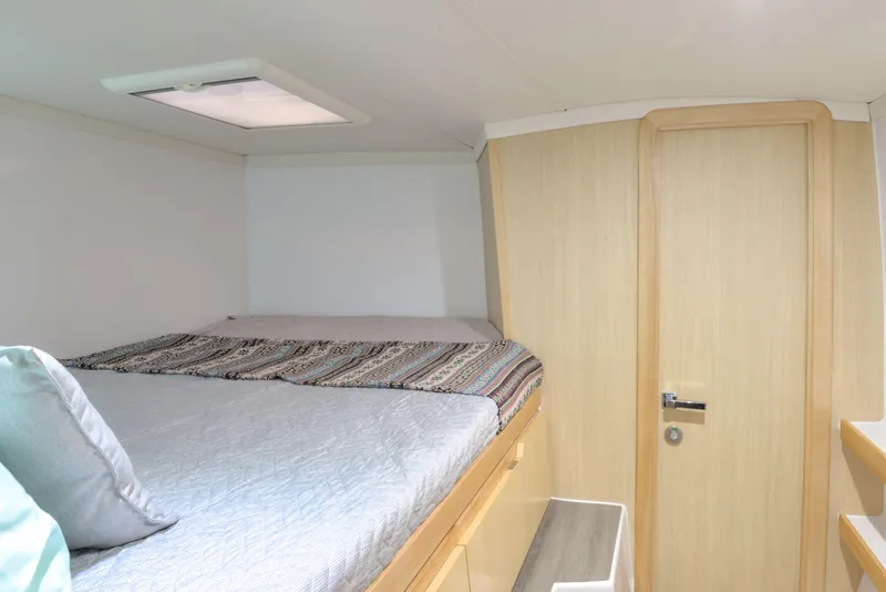 Slide: The Image of 2025 Seawind 1170 cabin interior with bed, wooden door, and skylight. - 30