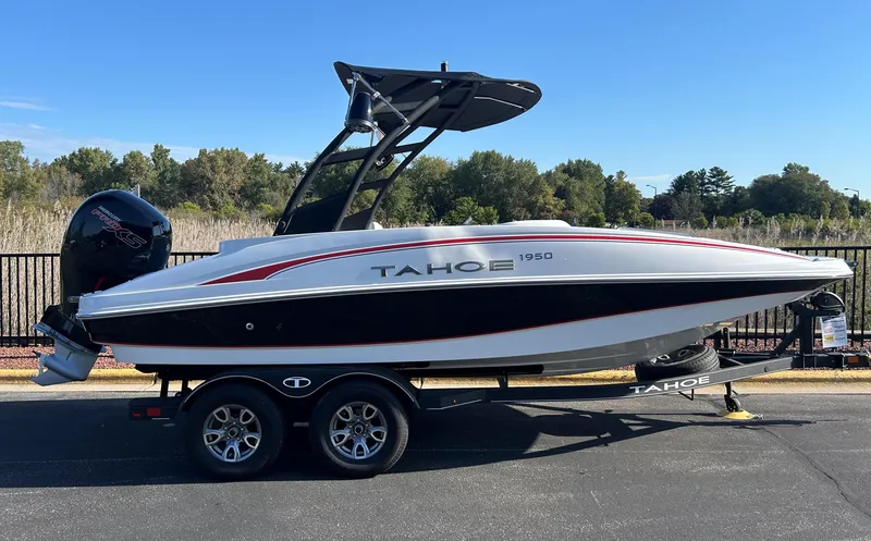 The Image of 2023 Tahoe 1950 boat on trailer, sleek design, black and white with red accents. - 0