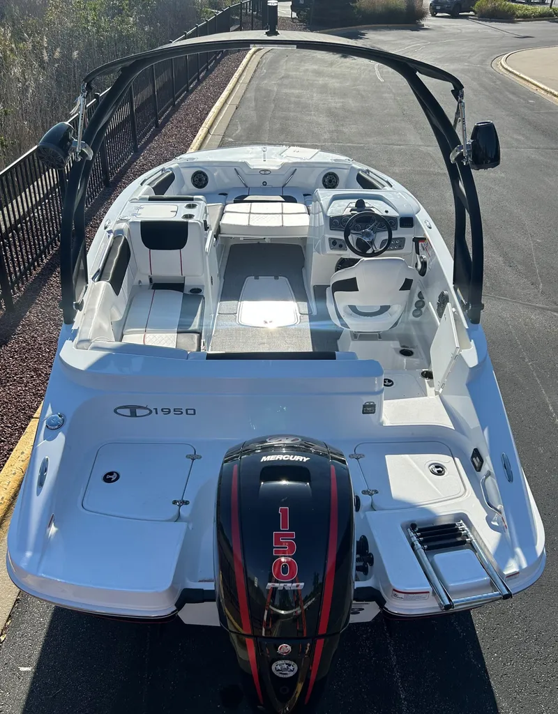 Slide: The Image of 2023 Tahoe 1950 boat with sleek design and powerful engine, parked on a sunny road. - 2