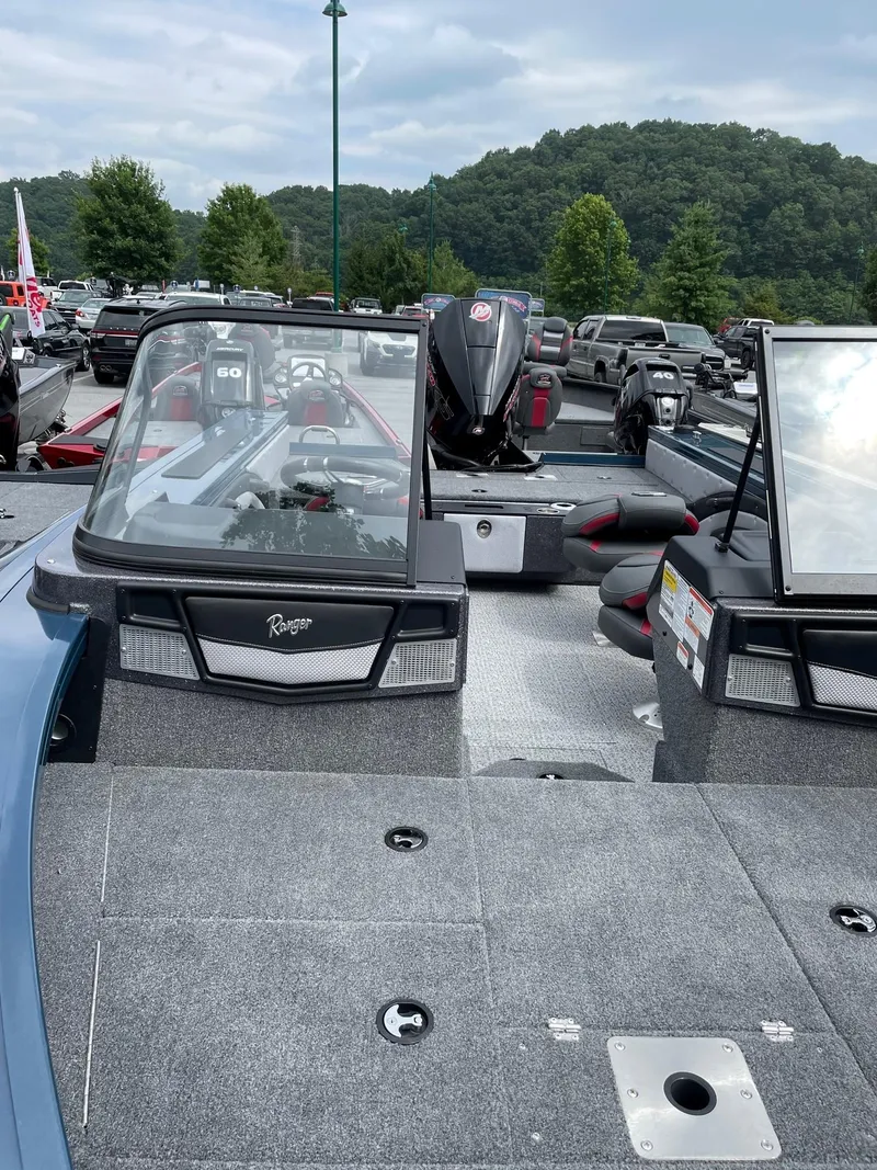 Slide: The Image of 2023 Ranger VX1888 WT fishing boat with dual consoles and outboard motor in a parking lot. - 6