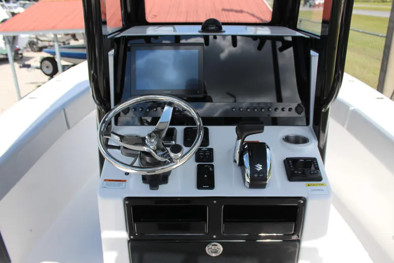 Slide: The Image of 2023 Blue Wave 2600 Makaira boat console with steering wheel and controls. - 4