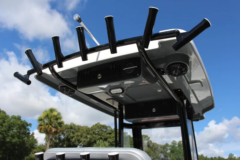 Slide: The Image of 2023 Blue Wave 2600 Makaira boat with rod holders and T-top against blue sky. - 5