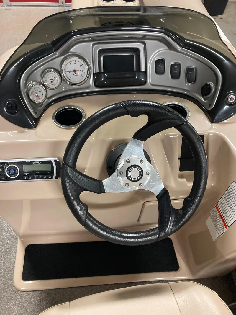 Slide: The Image of 2017 Sun Tracker Party Barge 20 DLX dashboard with steering wheel and gauges. - 9