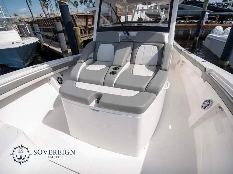 Slide: The Image of 2023 Regulator 41 boat with cushioned seating at Sovereign Yachts dock. - 17