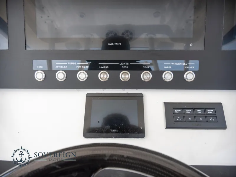 Slide: The Image of Control panel of a 2023 Regulator 41 yacht with Garmin display and various switches. - 32