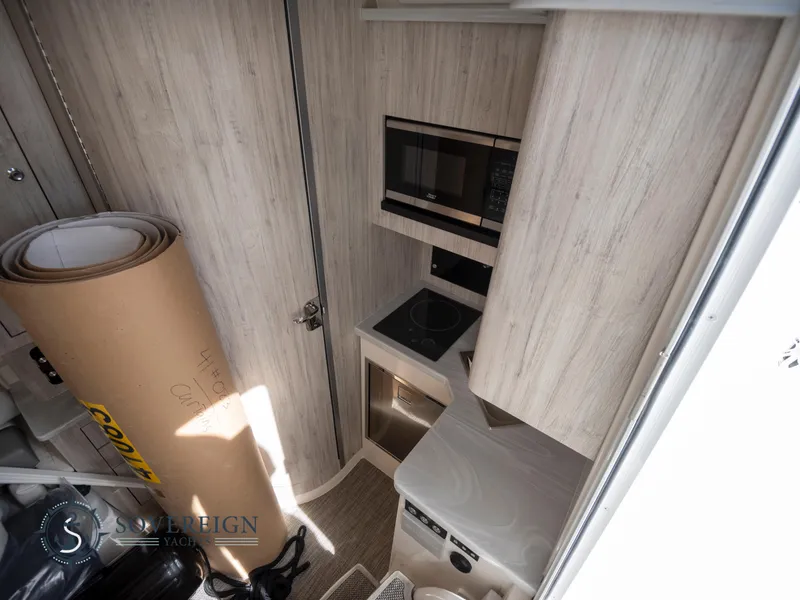 Slide: The Image of 2023 Regulator 41 yacht interior kitchen with microwave, stove, and storage. - 44