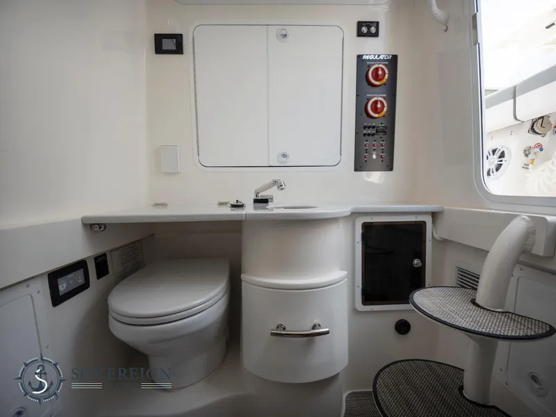 Slide: The Image of Modern bathroom in a 2023 Regulator 34 boat with toilet, sink, and control panel. - 14