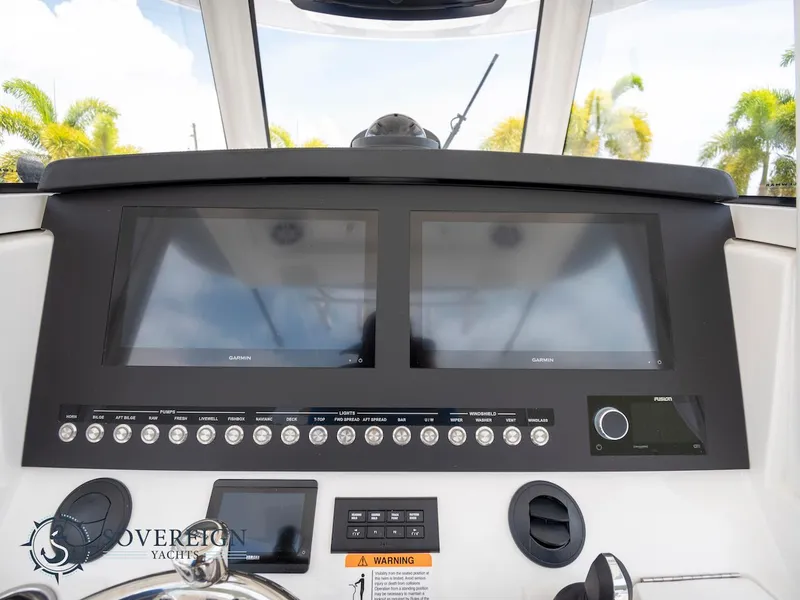 Slide: The Image of 2023 Regulator 34 boat dashboard with dual Garmin displays and control panel. - 19