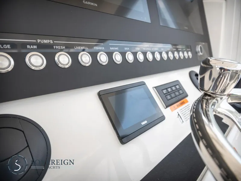 Slide: The Image of Control panel of a 2023 Regulator 34 boat with various switches and displays. - 21