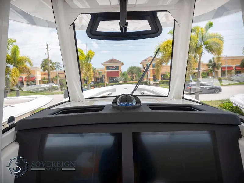 Slide: The Image of 2023 Regulator 34 boat dashboard with navigation screens and compass. - 27