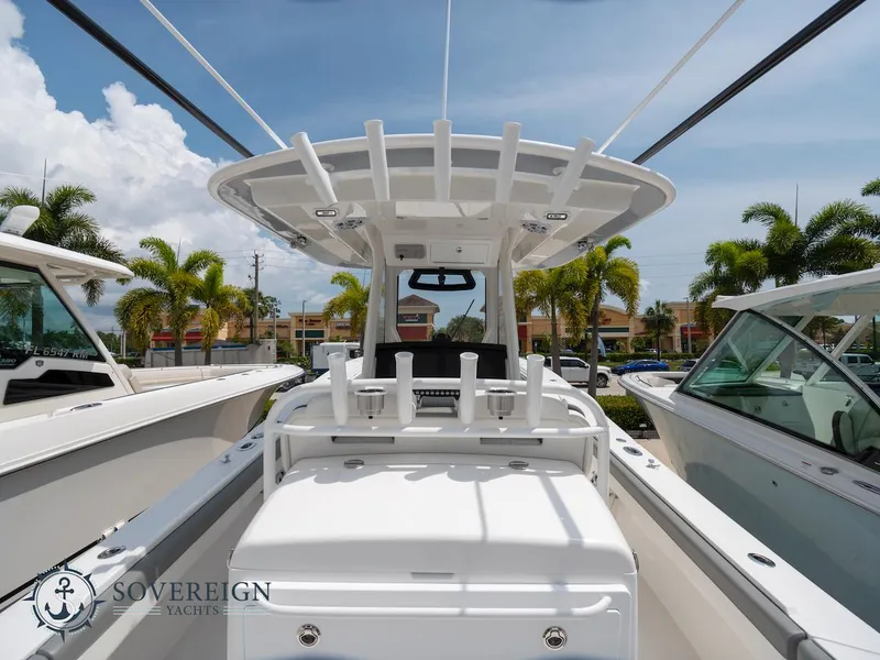 Slide: The Image of 2023 Regulator 34 boat at Sovereign Yachts dealership, showcasing center console and rod holders. - 34