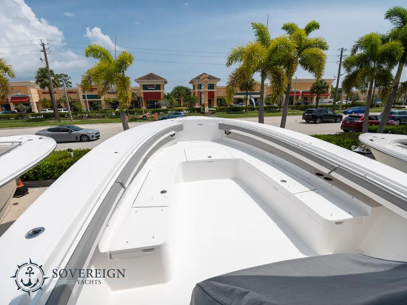 Slide: The Image of 2023 Regulator 34 boat deck with seating, Sovereign Yachts logo, palm trees, and shopping center background. - 40
