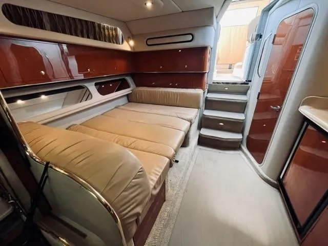 Slide: The Image of 2001 Sea Ray 340 AJ interior cabin with beige seating and wooden cabinetry. - 22