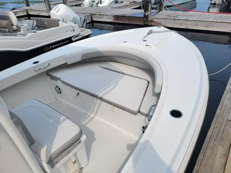 Slide: The Image of 2023 Parker 2100 SE boat interior at dock, featuring seating and storage. - 10