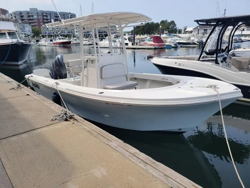 Slide: The Image of 2023 Parker 2100 SE boat docked in a marina with other vessels. - 11