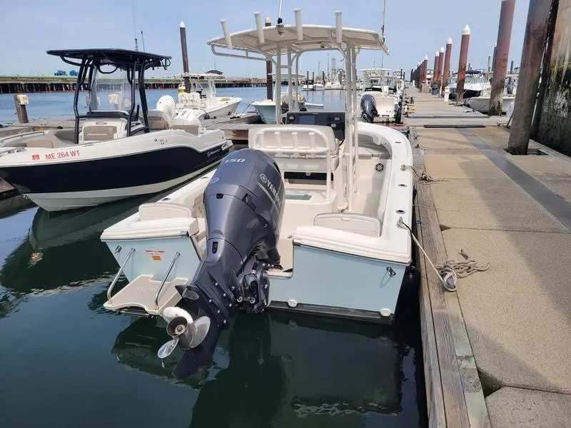 Slide: The Image of 2023 Parker 2100 SE boat docked at marina with outboard motor. - 13