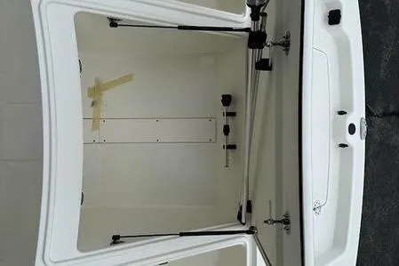 Slide: The Image of 2023 Mako SKIFF 19 CC boat storage compartment, open and empty, with hydraulic supports. - 10