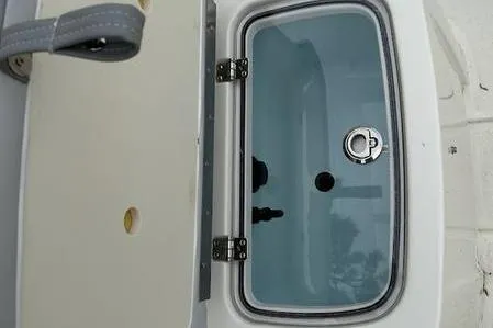 Slide: The Image of 2023 Mako SKIFF 19 CC boat compartment with open lid and latch. - 12