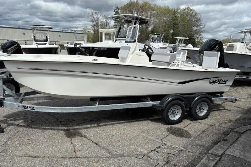 Slide: The Image of 2023 Mako SKIFF 19 CC boat on trailer, parked outdoors, cloudy sky background. - 18
