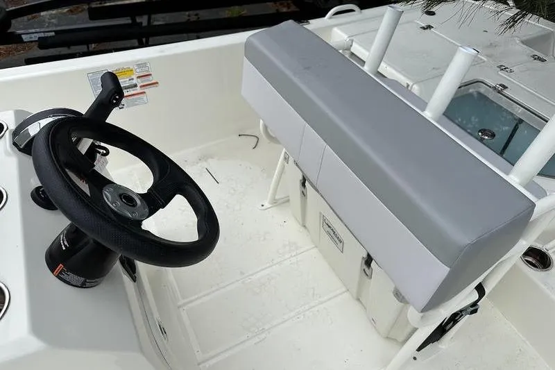 Slide: The Image of 2023 Mako SKIFF 19 CC boat interior with steering wheel and seating area. - 19