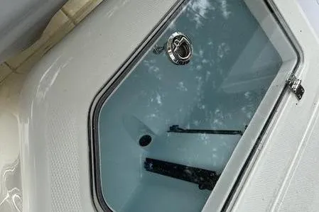 Slide: The Image of 2023 Mako SKIFF 19 CC boat compartment with secure latch and clear window. - 5