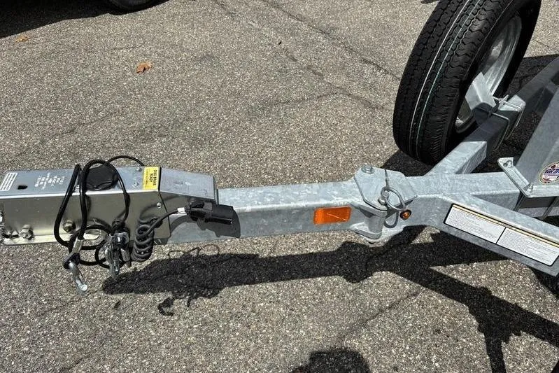 Slide: The Image of Trailer hitch and wheel of 2023 Mako SKIFF 19 CC on asphalt surface. - 6