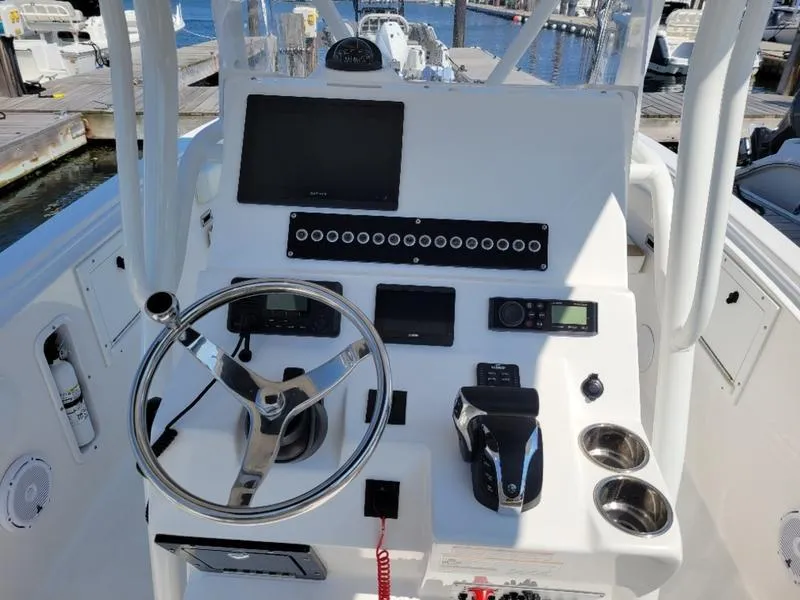 Slide: The Image of Edgewater 245 CC 2023 boat console with steering wheel and navigation controls. - 10