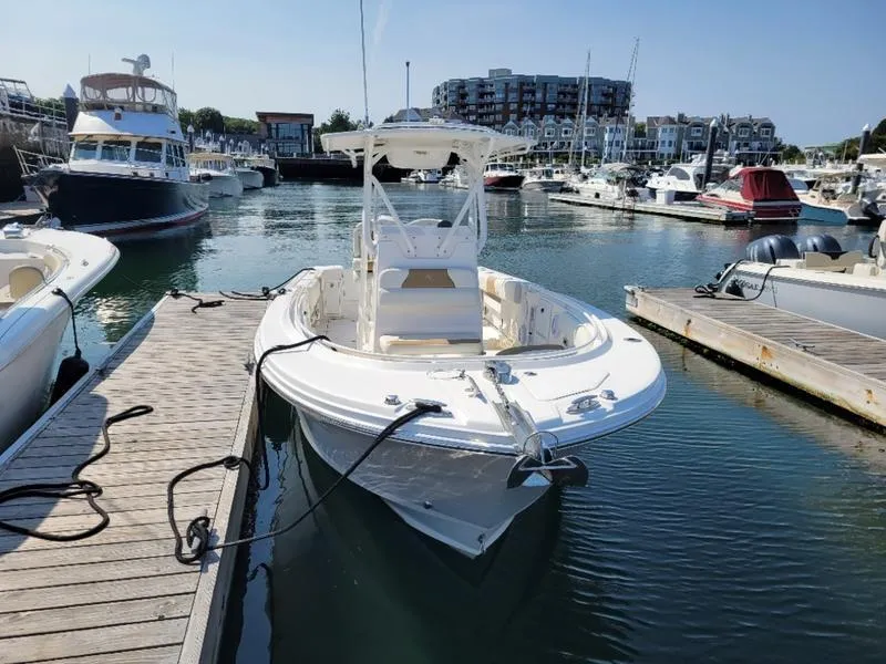 Slide: The Image of 2023 Edgewater 245 CC boat docked in a marina, surrounded by other vessels. - 15