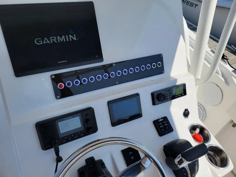 Slide: The Image of Edgewater 245 CC 2023 boat dashboard with Garmin navigation system and control panel. - 9