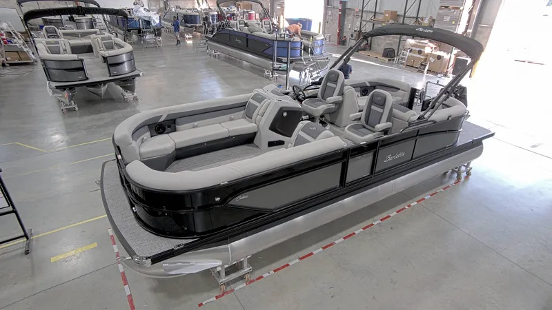 Slide: The Image of 2024 Barletta C24QC pontoon boat in a showroom, featuring sleek design and spacious seating. - 1